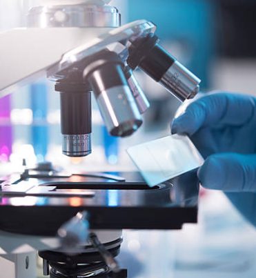 A scientist placing a slide under a microscope